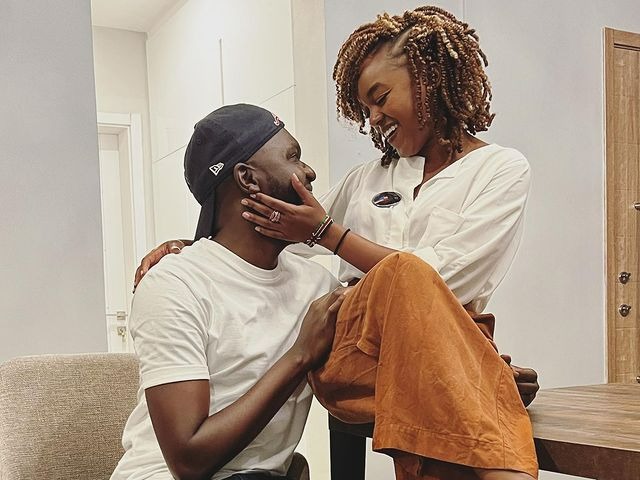 Edith is wearing a white t-shirt and brown pants, whereas Larry wearing white t-shirt and black cap.